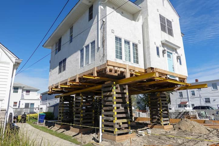 A team of professionals using specialized equipment to raise a house in Stafford, preparing it for elevation and renovation